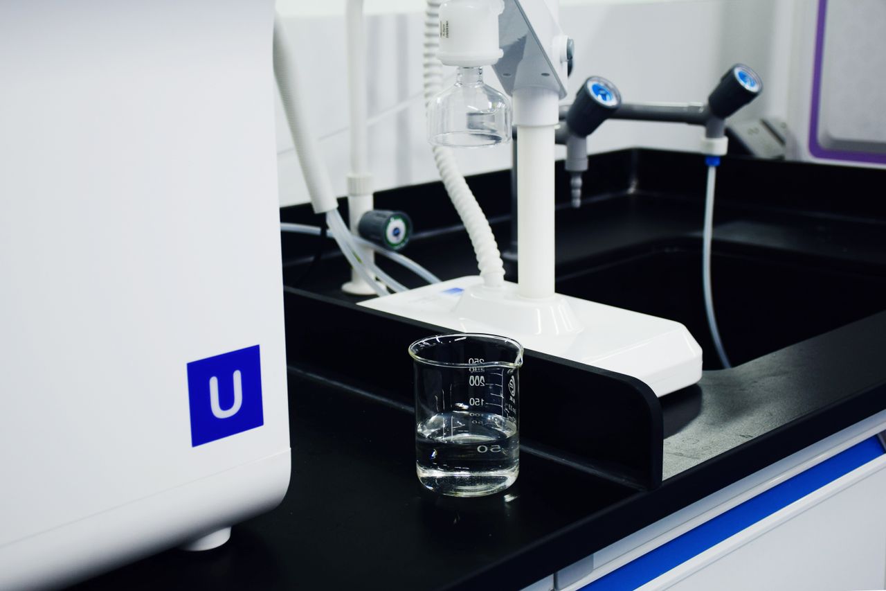 Close-up of modern laboratory equipment including a glass beaker and apparatus in a professional lab setting.